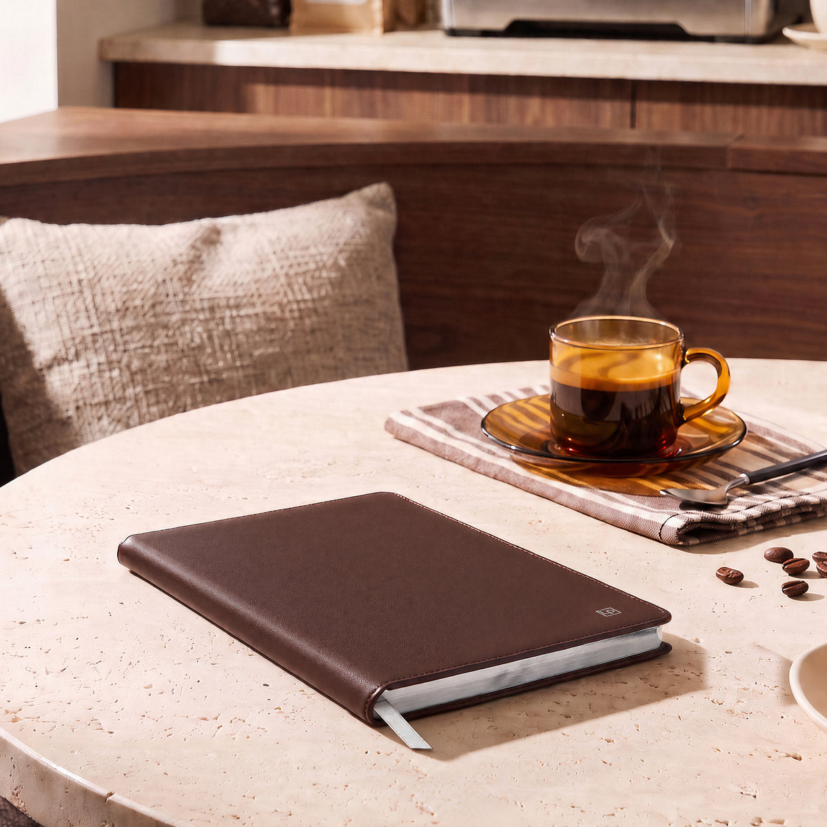 A Cacao Brown Heritage journal on a table beside a cup of tea
