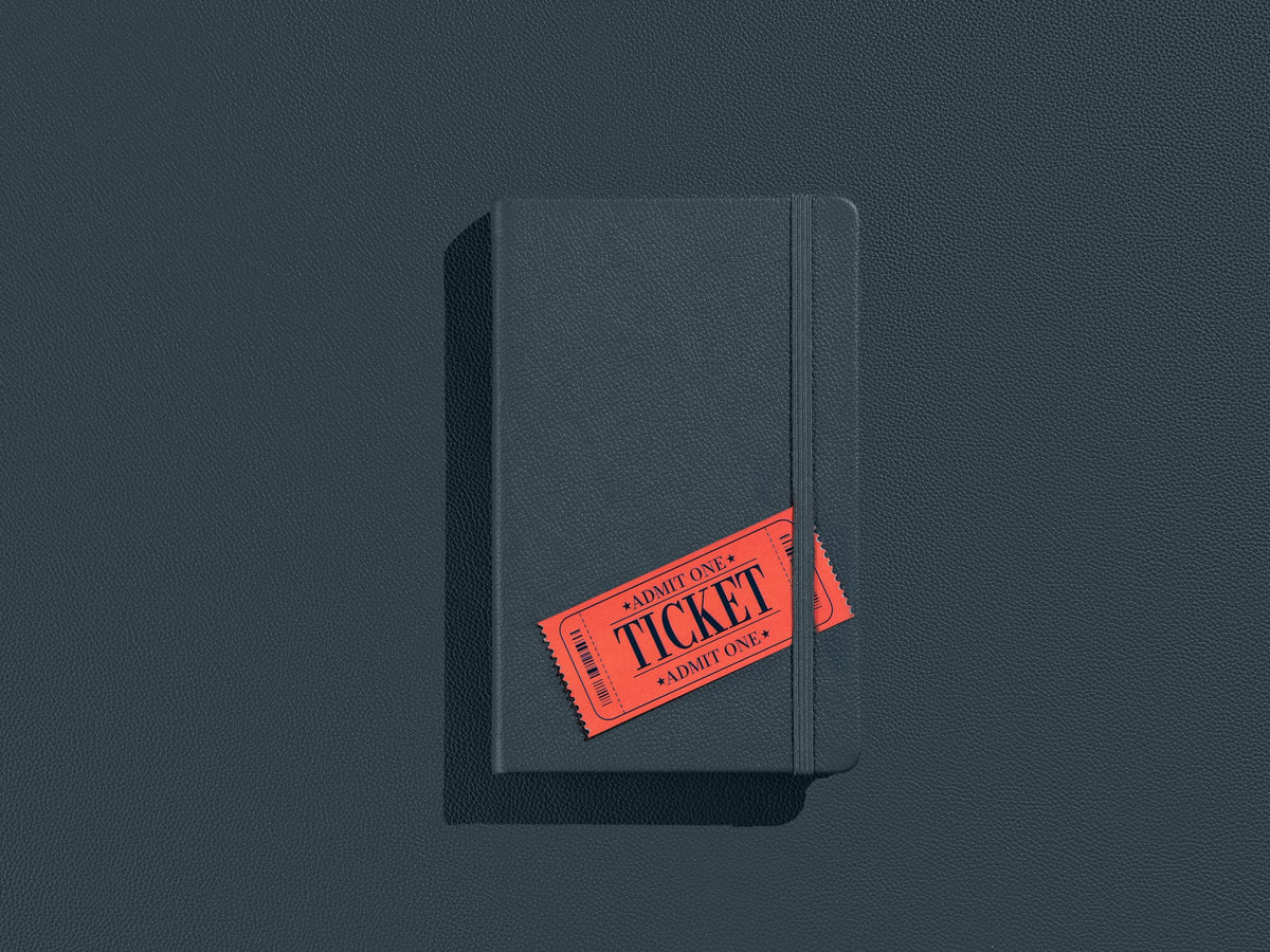 A Twilight Gray Inspire notebook with a ticket tucked under its elastic band