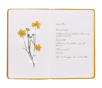Open Butter Yellow leather notebook used as a garden planning journal with plans for upcoming plantings